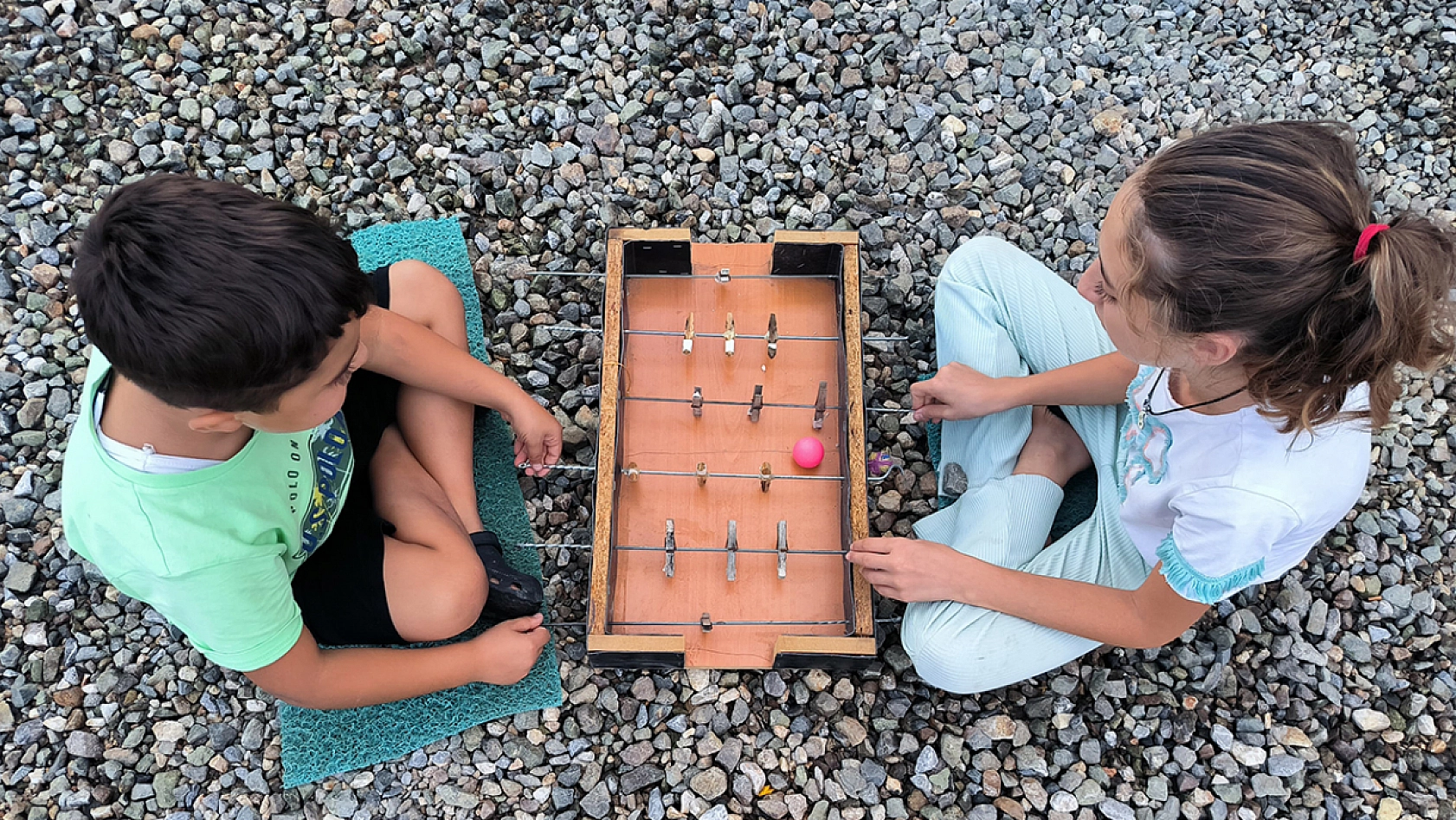 Konteynerdeki çocukların çamaşır mandalı ve şişten yaptıkları langırt en büyük eğlenceleri oldu