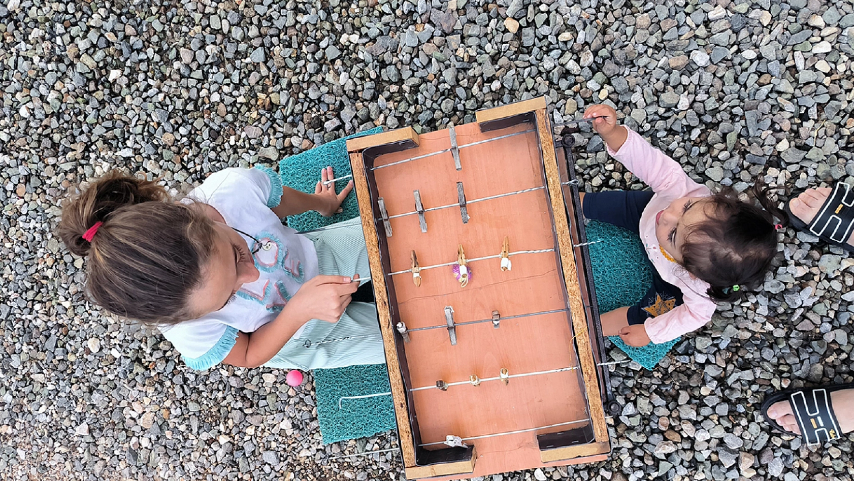 Konteynerdeki çocukların çamaşır mandalı ve şişten yaptıkları langırt en büyük eğlenceleri oldu
