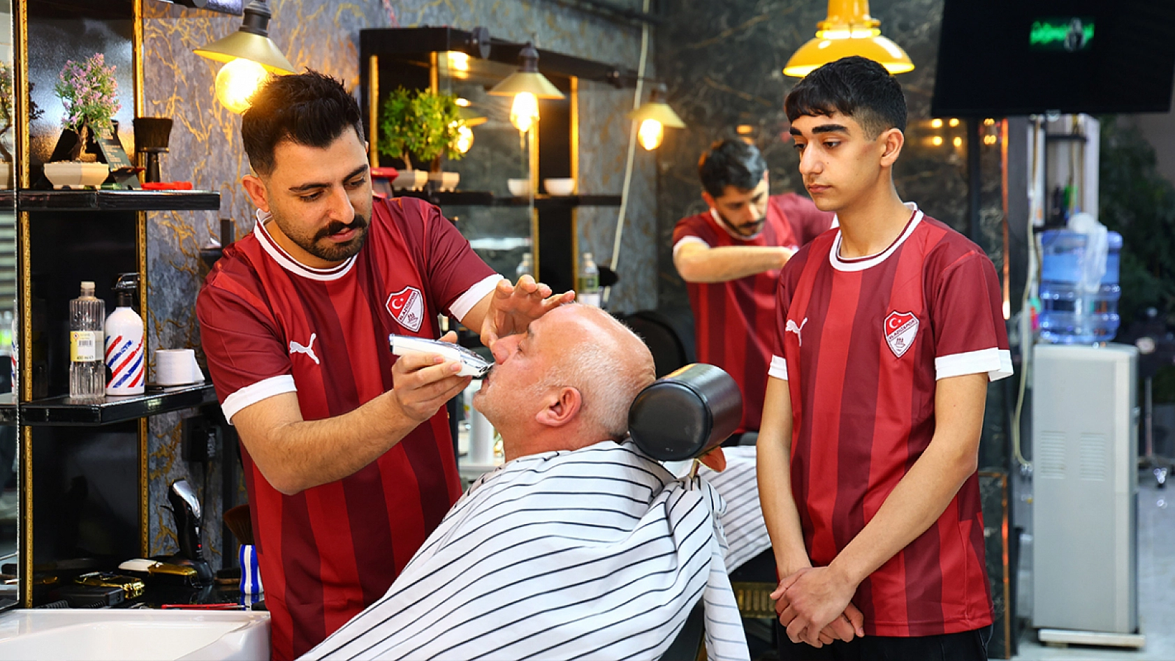 Dükkanı bordo-beyaza boyadı, müşterilere forma dağıttı
