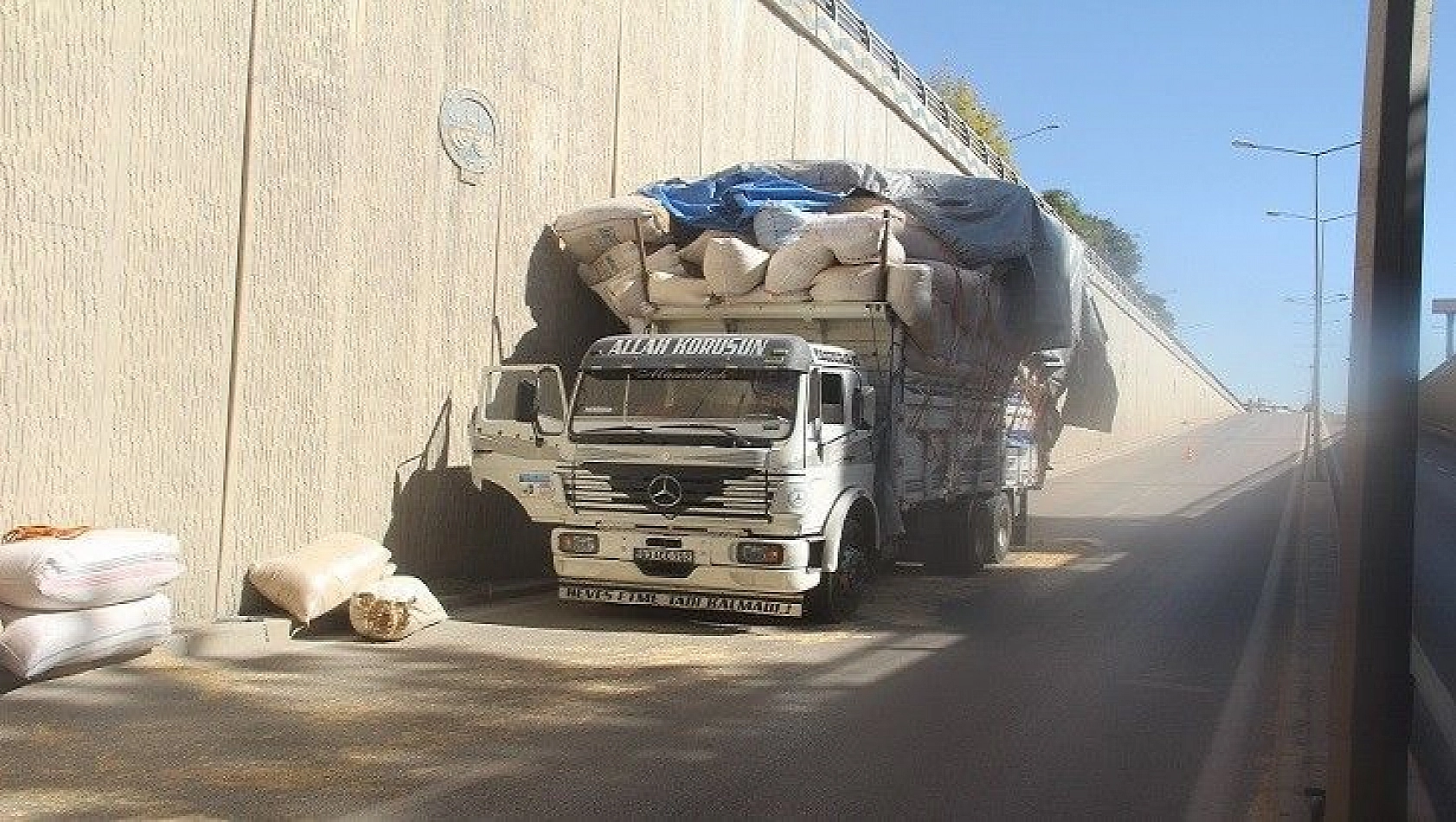 Saman yüklü kamyon alt geçide takıldı, yola savrulan çuvallar trafiği kilitledi