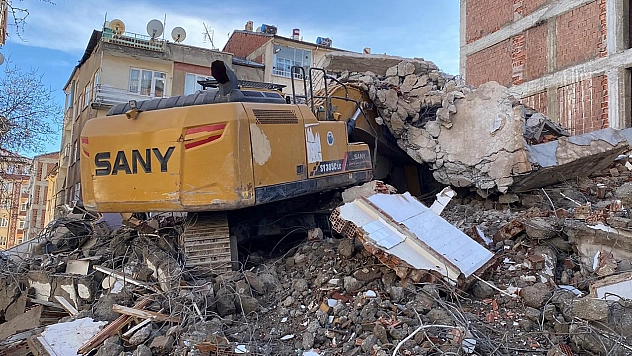 Elazığ'da ağır hasarlı binanın enkazı iş makinesinin üstüne yıkıldı