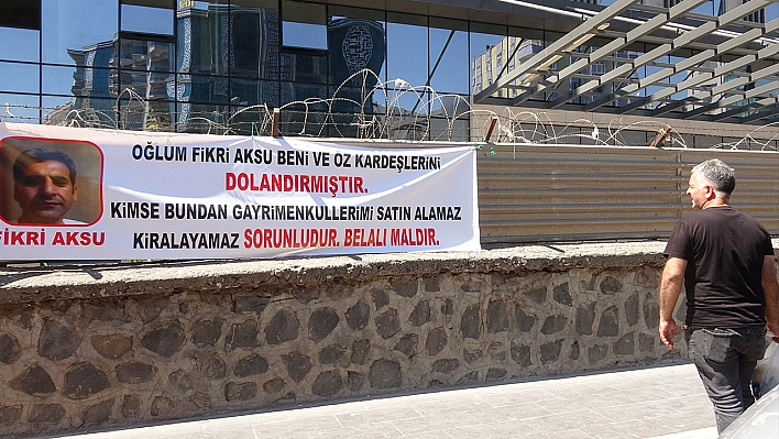 Oğlu tarafından dolandırıldığını iddia eden baba, olayı pankartla duyurdu