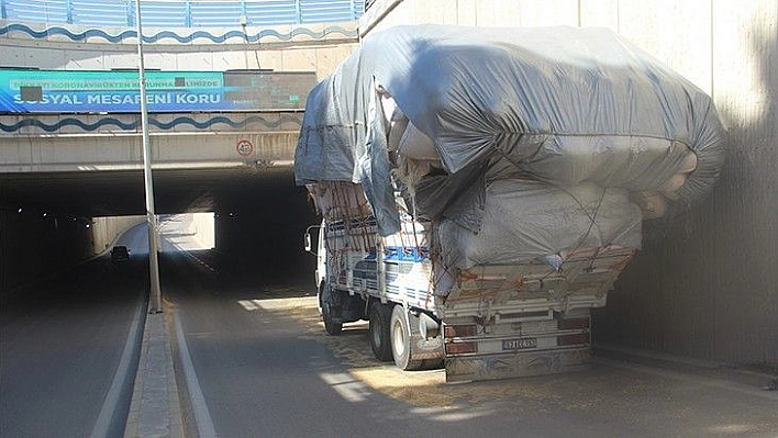 Saman yüklü kamyon alt geçide takıldı, yola savrulan çuvallar trafiği kilitledi